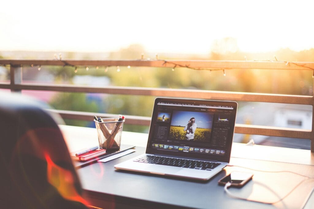 pexels-photo-196660-196660 A modern workspace on a balcony with a laptop and smartphone during sunset, capturing a creative work environment.